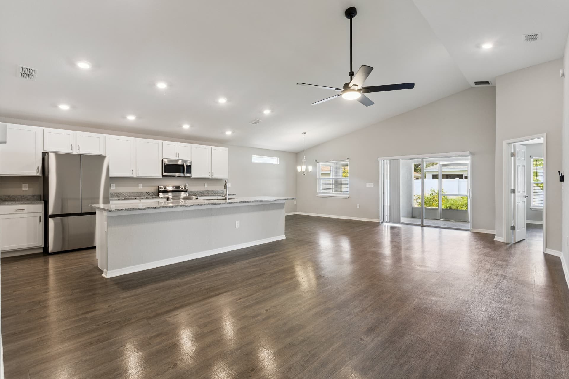 Open floor plan with kitchen, island, and vaulted ceiling